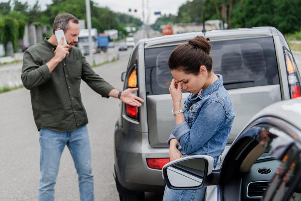 Driver inspecting vehicle damage after a NJ car accident highlighting common mistakes to avoid