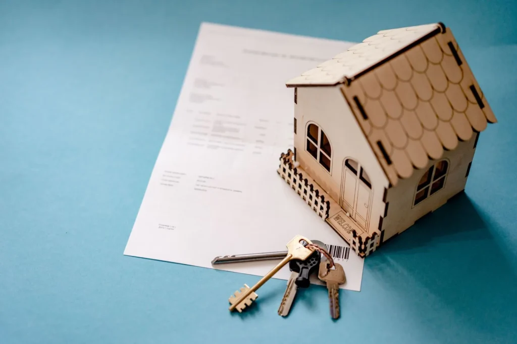 Real estate contract, keys, and miniature house representing specific performance of a property sale agreement in Monmouth County, New Jersey